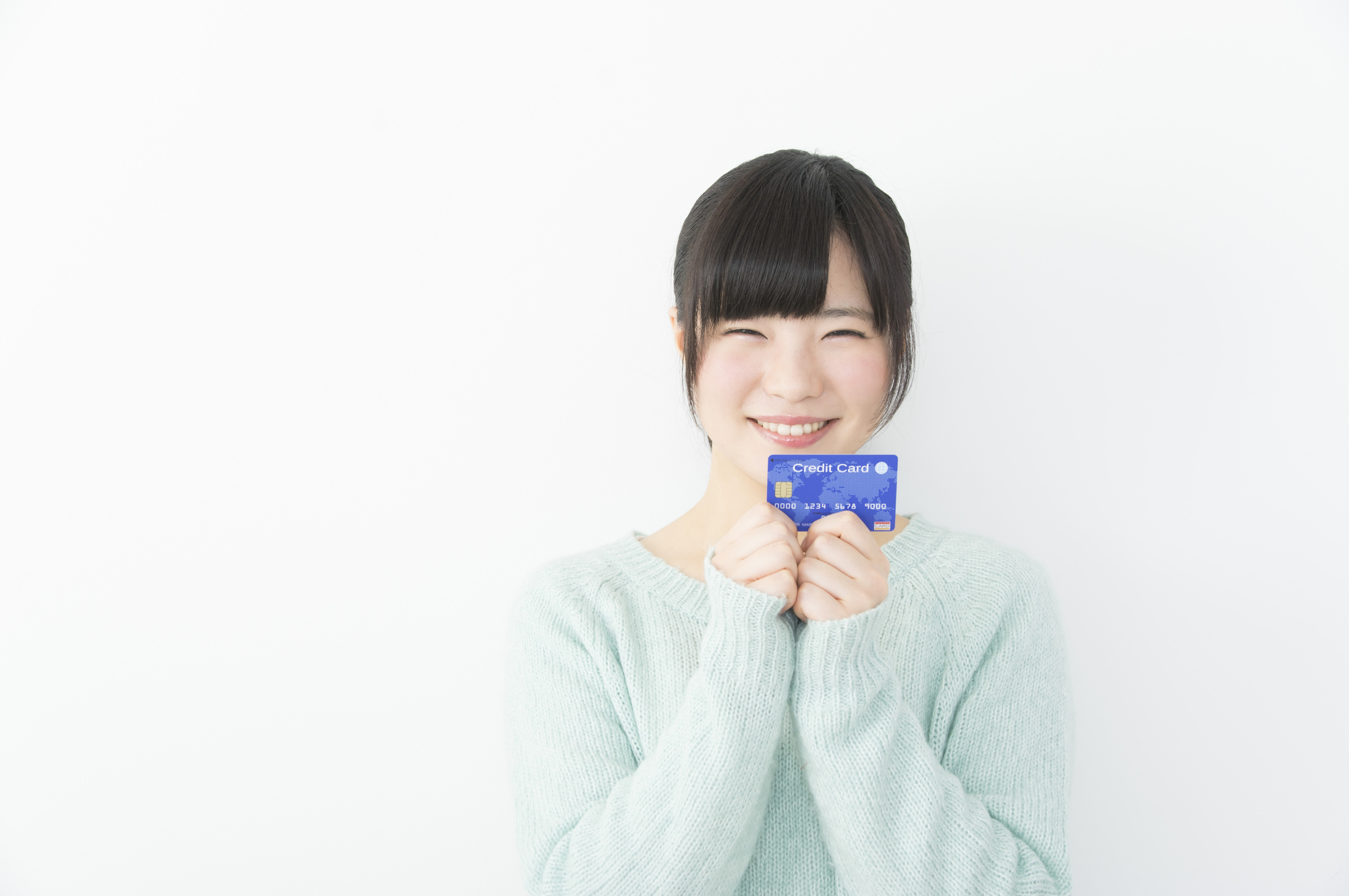 クレジットカードを持って笑顔の若い女性